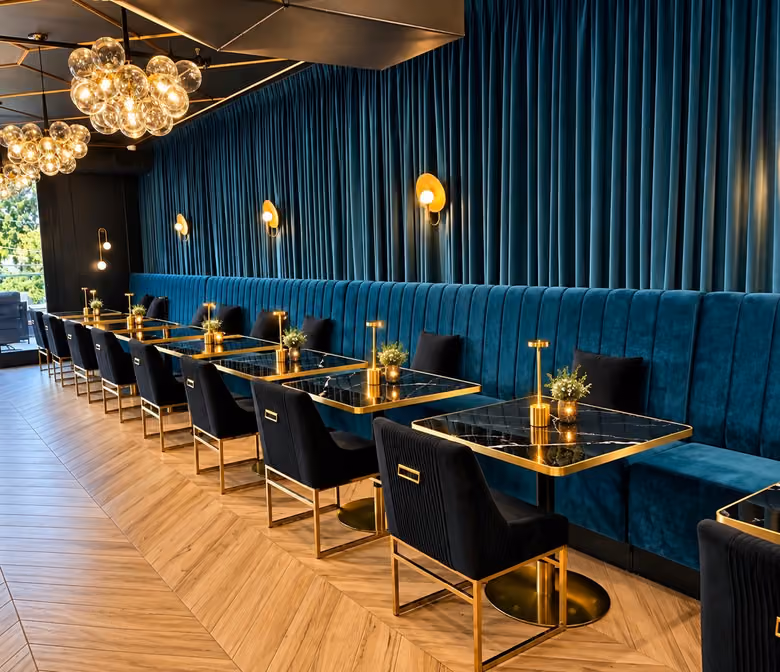 Teal velvet banquettes and set tables in the Il&nbsp;Vero dining room
